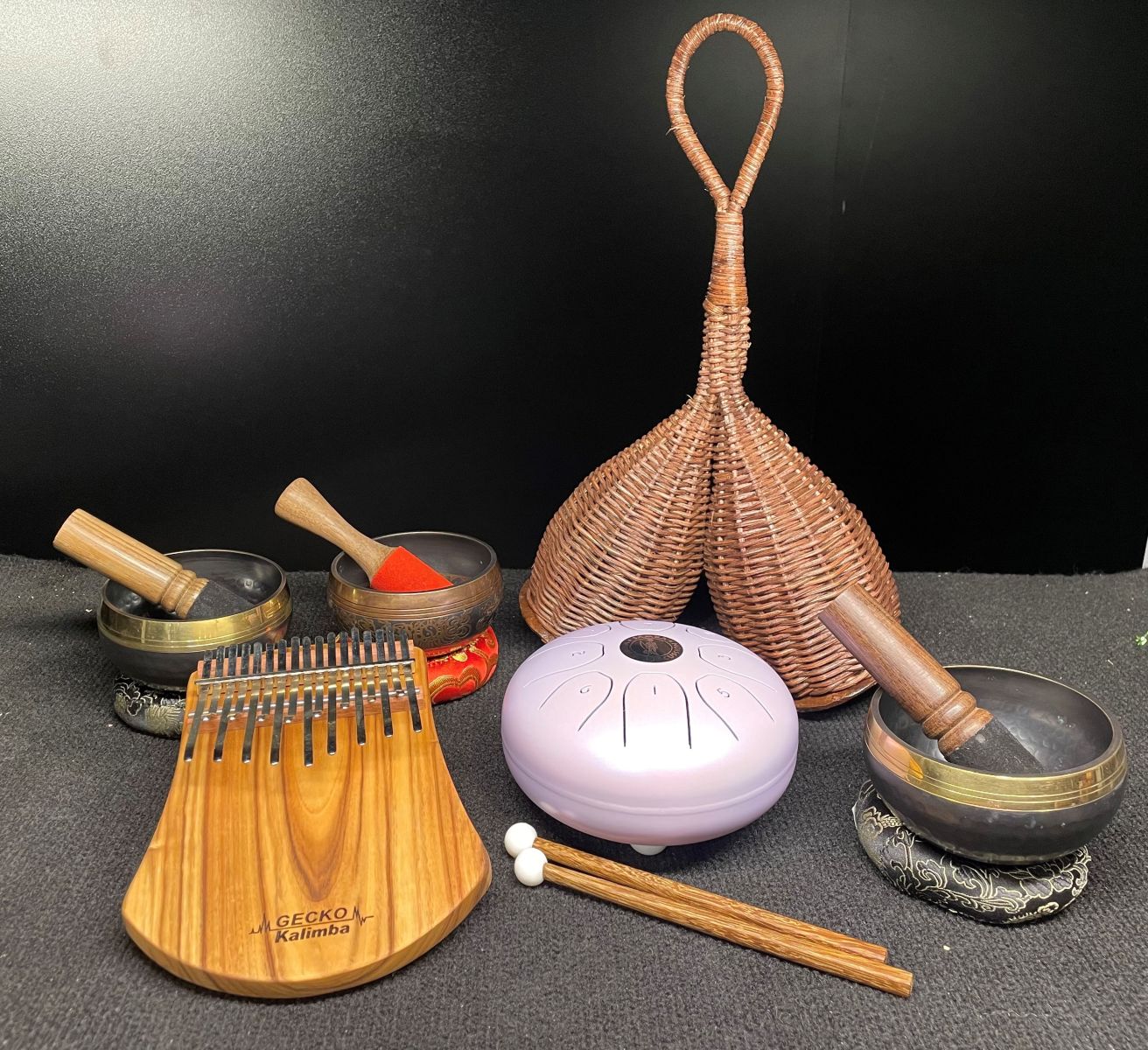 A collection of sound healing instruments available at Groove Warehouse, including kalimbas, Tibetan singing bowls, tongue drums and double caxixi 
